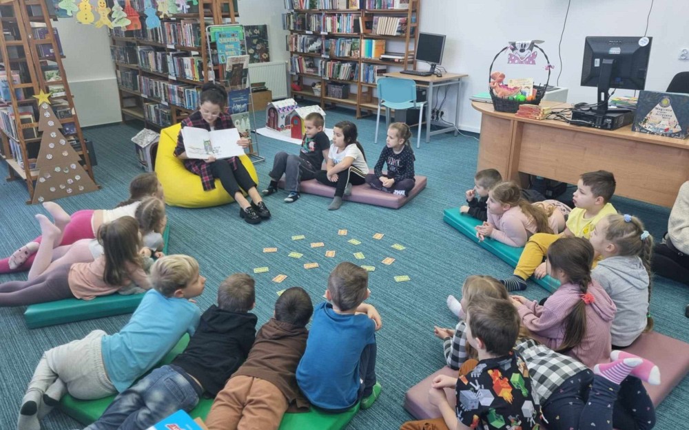 bibliotekarka czyta opowiadanie "Kolorowy potwór" autorstwa  LLenas Anna
