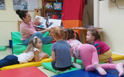 Bibliotekarka czyta książkę dzieciom