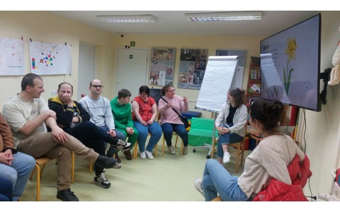 Bibliotekarka wraz z uczestnikami Warsztatów Terapii Zajęciowej podczas zajęć
