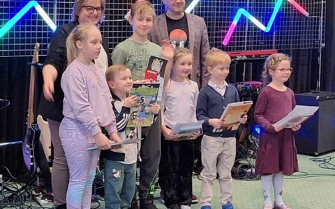 Na zdjęciu Ewa i sześcioro nagrodzonych młodych czytelników z filii nr 6 pozują z Dyrektorem Biblioteki - Dariuszem Pawlikowskim