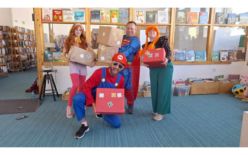 Superbohaterowie prezentują paczki z książkami