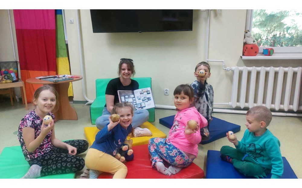 Bibliotekarka i dzieci w trakcie czytania książeczki