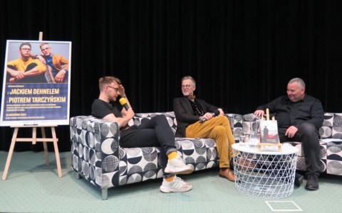 Widok na scenę KBP. Na kanapach siedzą, od lewej Piotr Tarczyński, który wypowiada się do mikrofonu, Jacek Dehnel i Piotr Pawłowski.