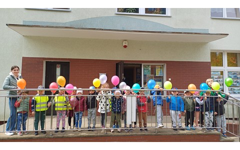 Na zdjęciu grupa PSZCZÓŁEK pozuje z balonami przed naszą biblioteką