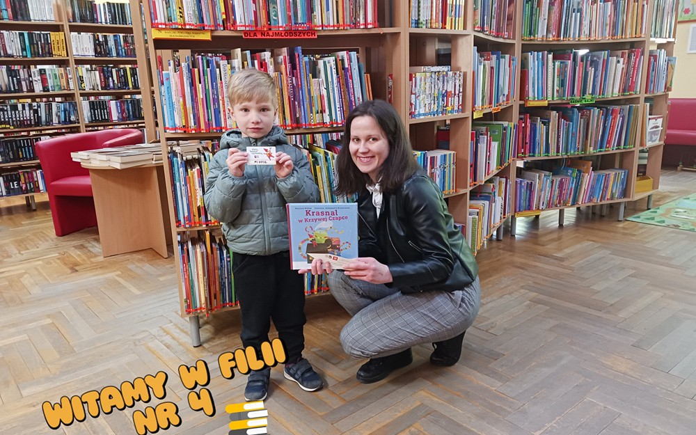 Bibliotekarka z chłopcem trzymają książkę i kartę biblioteczną