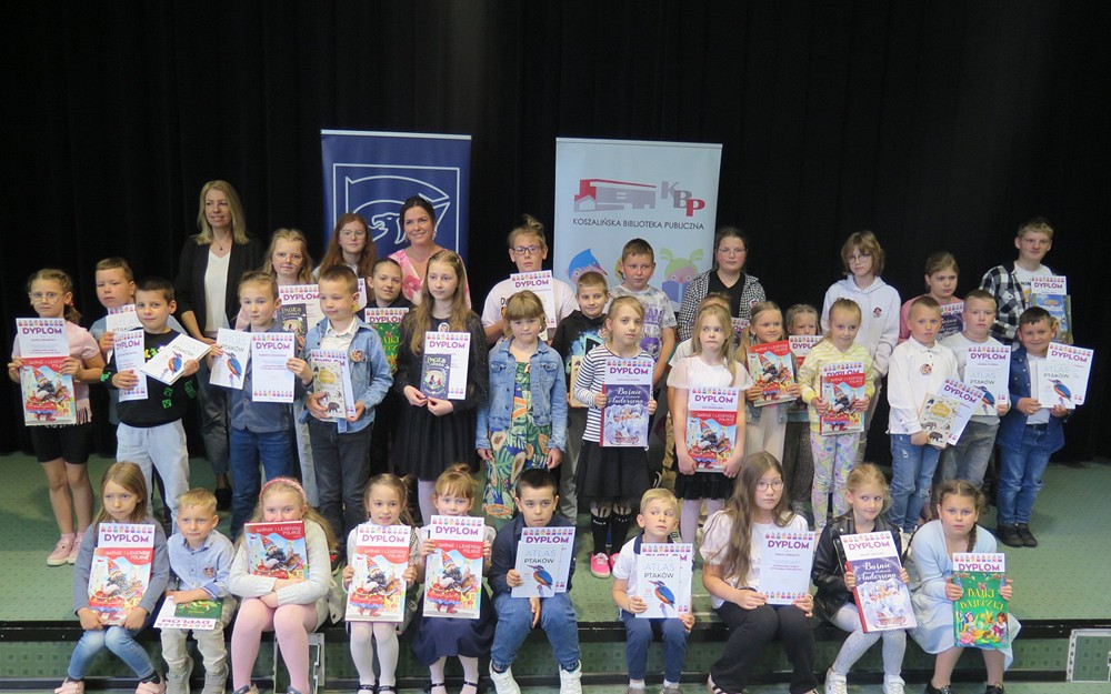 Zdjecie grupowe najlepszych czytelników powiatu koszalińskiego wraz z Wicestarostą Koszalińską i Zastępcą dyrektora KBP