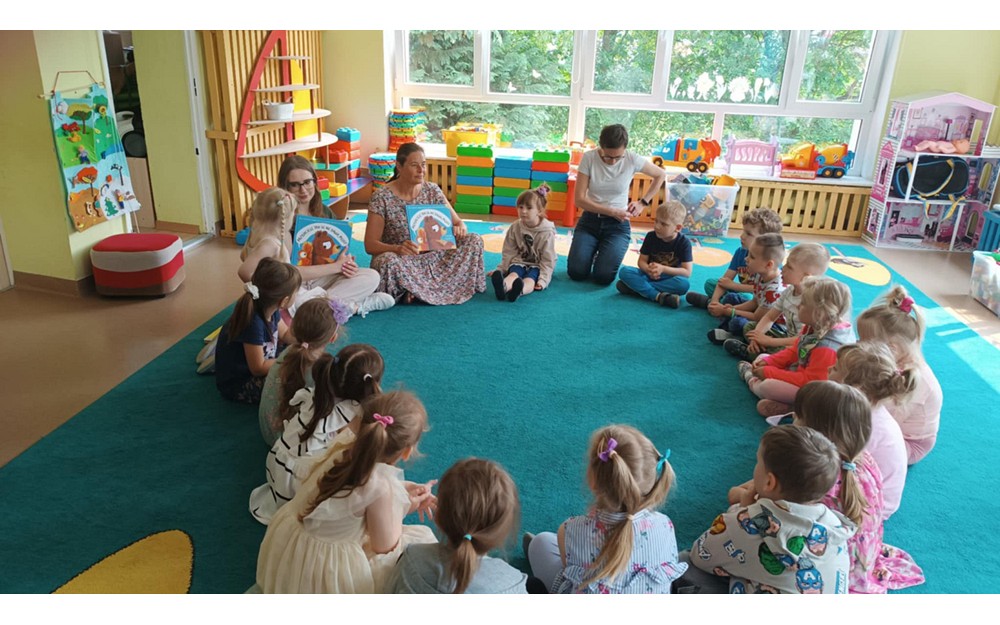 Bibliotekarki pokazują książkę dzieciom