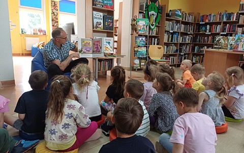 Na zdjęciu nasz gość Piotr Saporowski czyta przedszkolakom książeczkę o dinozaurach