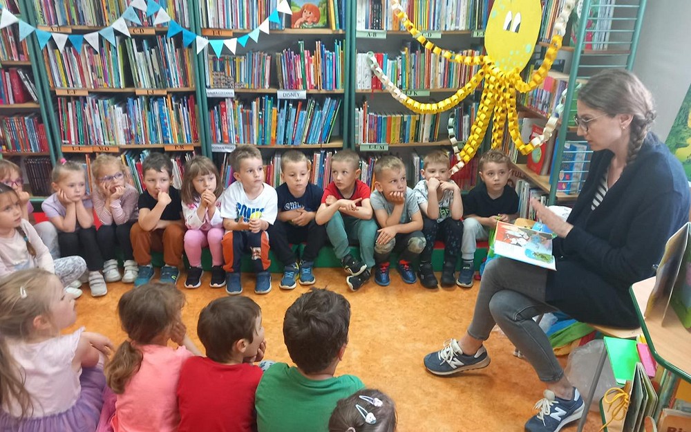 Dzieci słuchają opowiadania o przygodach Muminków.