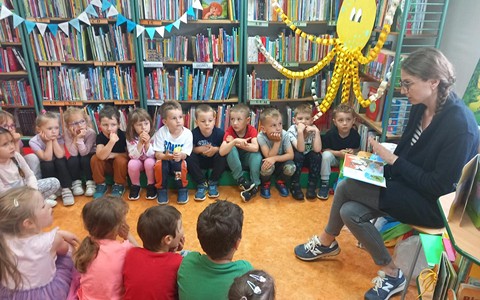 Dzieci słuchają opowiadania o przygodach Muminków.