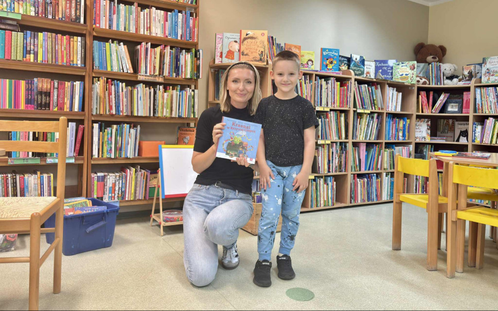 Chłopiec pozuje do zdjęcia z bibliotekarką