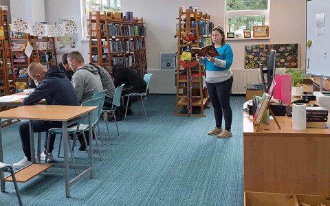 panowie słuchają opowiadania czytanego przez bibliotekarkę