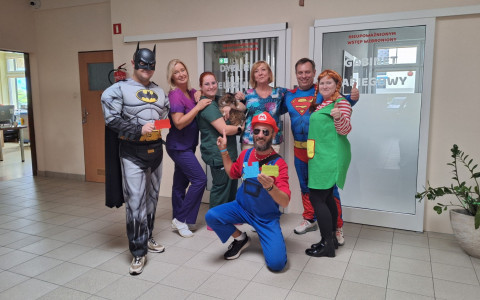 SuperBohaterowie pozują do zdjęcia z personelem hospicjum i kotem