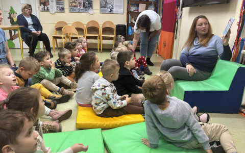 Bibliotekarka czyta książeczkę dzieciom