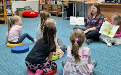 bibliotekarka z małą czytelniczką czytają opowiadanie