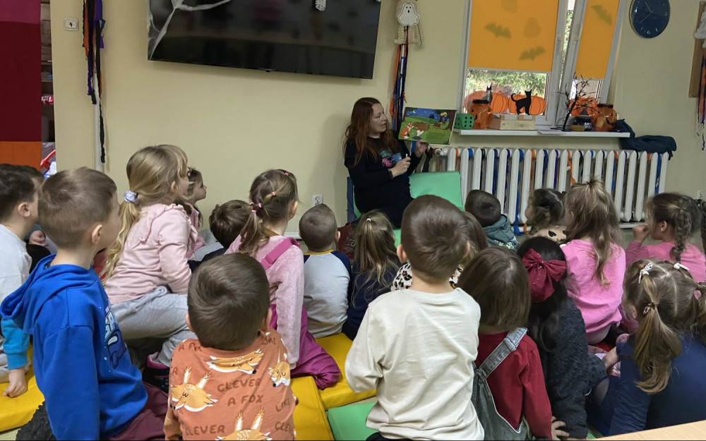 Bibliotekarka czyta książeczkę dzieciom