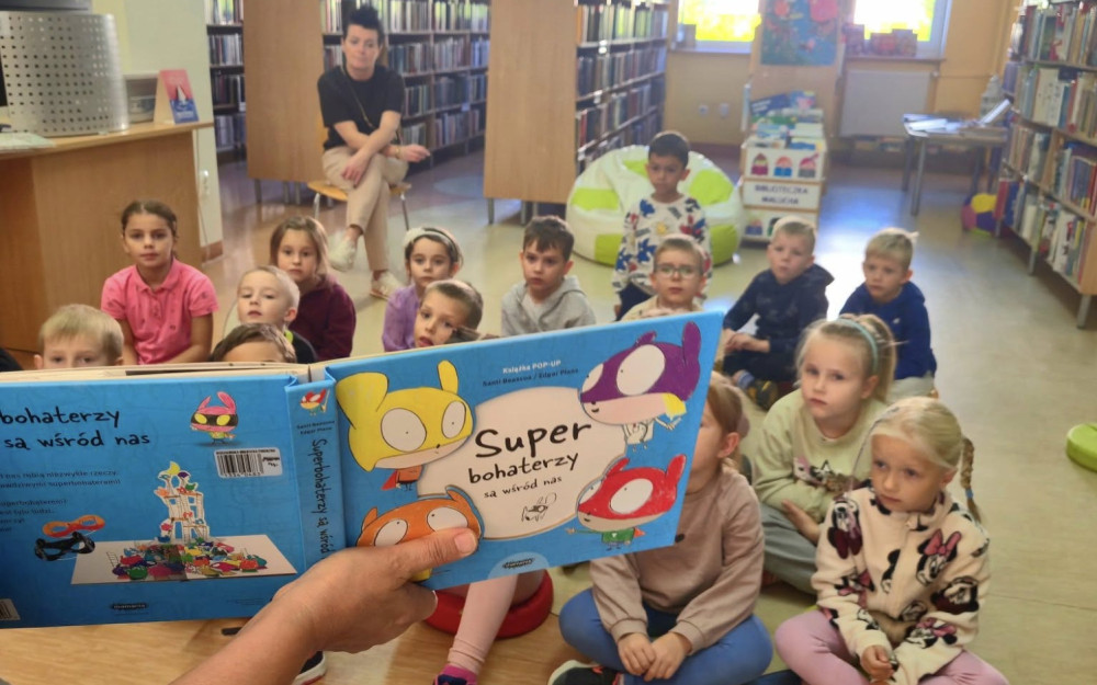 Wiola czyta Ekotropkom książkę Superbohaterzy są wśród nas, autorstwa Santi Beascoa