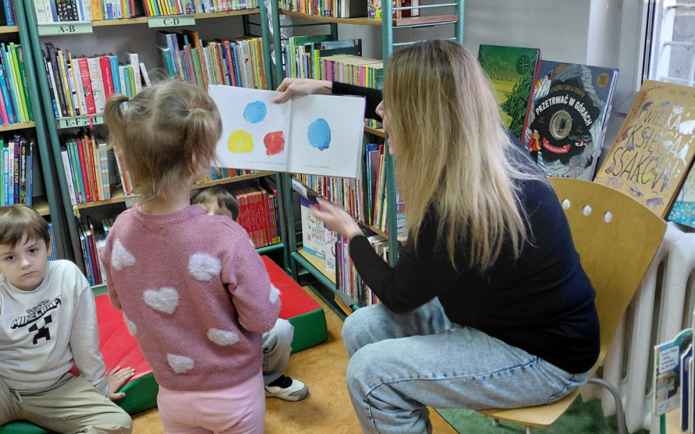 Bibliotekarka czyta dzieciom książkę.