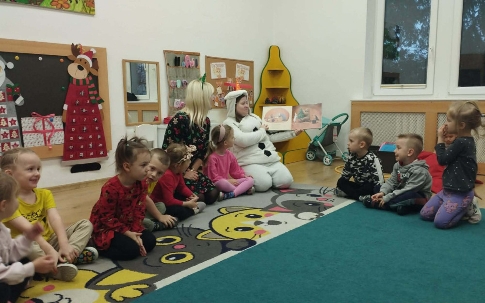 bibliotekarka i jej pomocnik Elfica czytają dzieciom opowiadanie