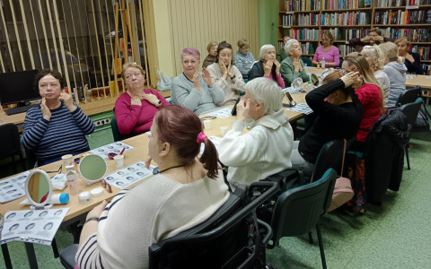 Uczestnicy podczas ćwiczeń masażu twarzy.