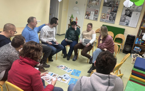 Uczesticy spotkania siedzą w kole i dyskutują