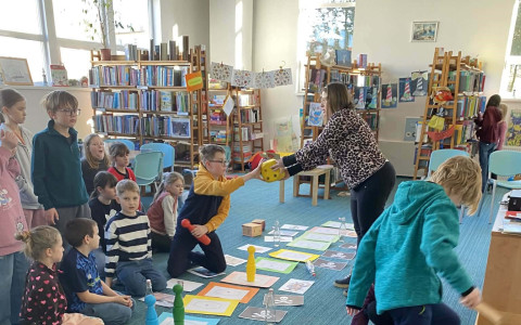 dzieci grają w dużą grę planszową na dywanie o tematyce morskiej