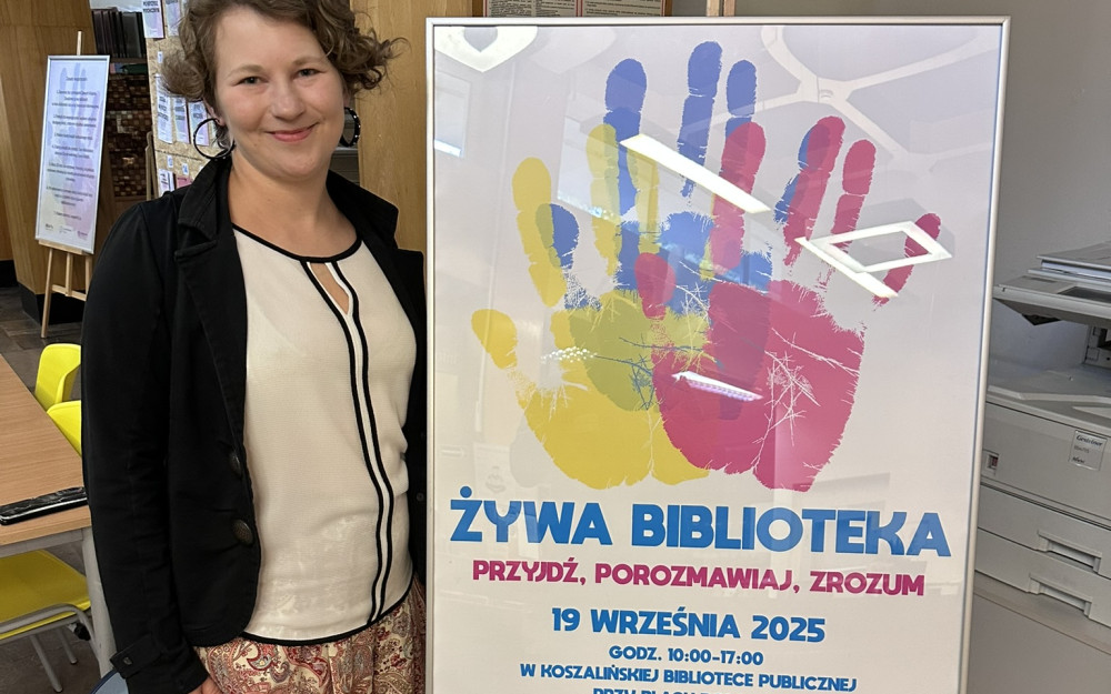 Bibliotekarka prezentuje plakat Żywej Biblioteki