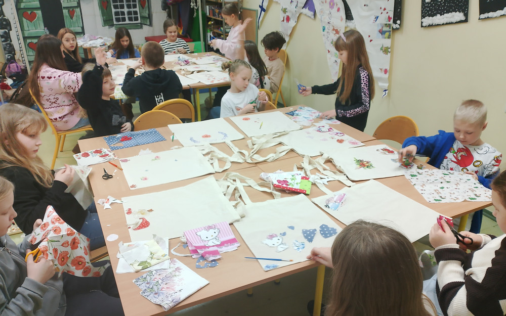 Dzieci wycinąją serwetki podczas warsztatów decoupage