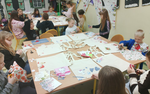 Dzieci wycinąją serwetki podczas warsztatów decoupage