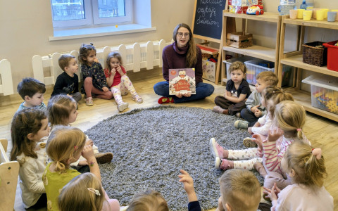 Bibliotekarka czyta przedszkolakom książkę Katy Hudson pt. "Wielkie zawody"