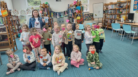 Dzieci pozują do zdjęcia z ozdobionego przez siebie serduszkami