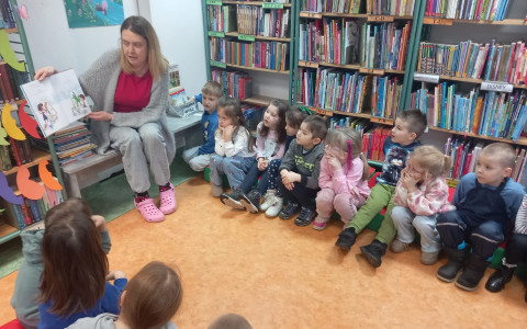 Bibliotekarka czyta dzieciom książkę.