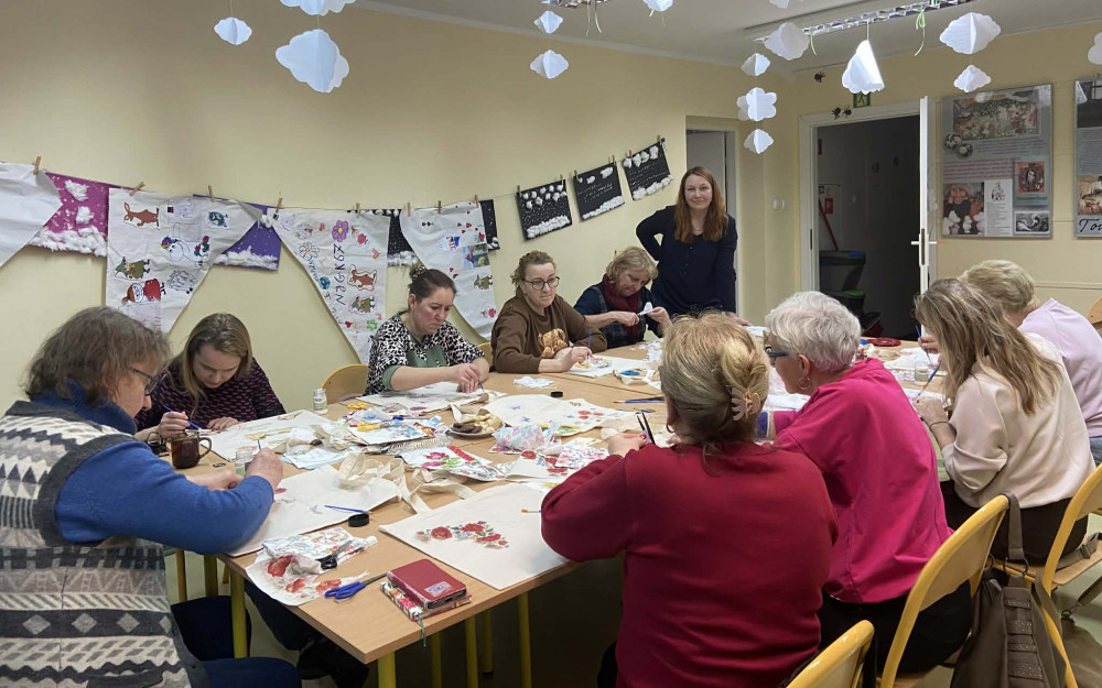 Uczestniczki warsztatów decoupage przyklejają serwetki do bawełnianych toreb