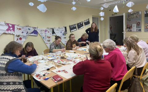 Uczestniczki warsztatów decoupage przyklejają serwetki do bawełnianych toreb