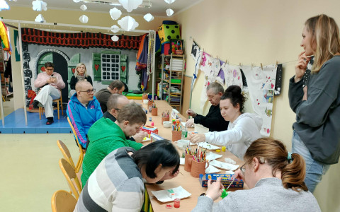 Uczestnicy spotkania podczas malowania gipsowych figurek
