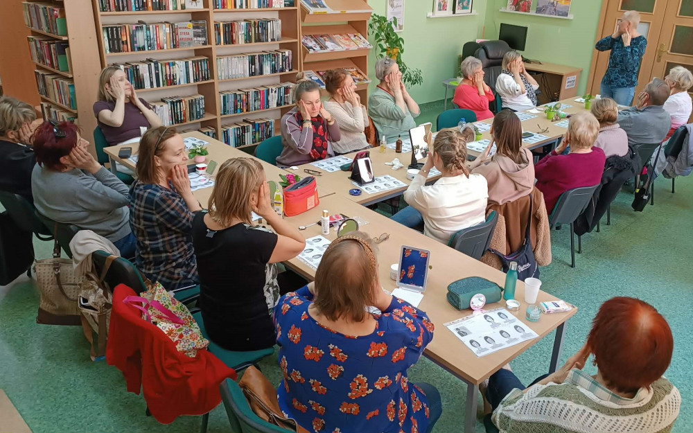 Uczestnicy spotkania podczas wykonywania masażu twarzy.