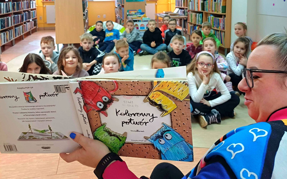 Na zdjęciu Gosia czyta pierwszoklasistom historię o kolorowym potworze