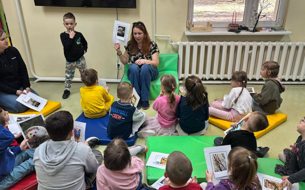 Bibliotekarka z dziećmi rozmawiają o oznakach wiosny