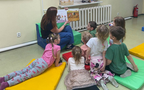 Bibliotekarka czyta książkę dzieciom