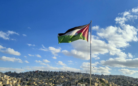 Na zdjęciu panorama Ammanu z flagą Jordanii na pierwszym planie