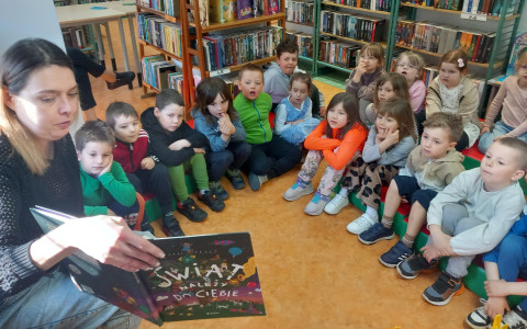 Bibliotekarka czyta dzieciom książkę.