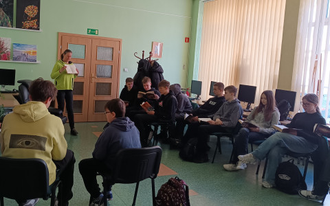 Bibliotekarka wyjaśnia uczniom, co to jest sygnatura i numer inwentarzowy książki.