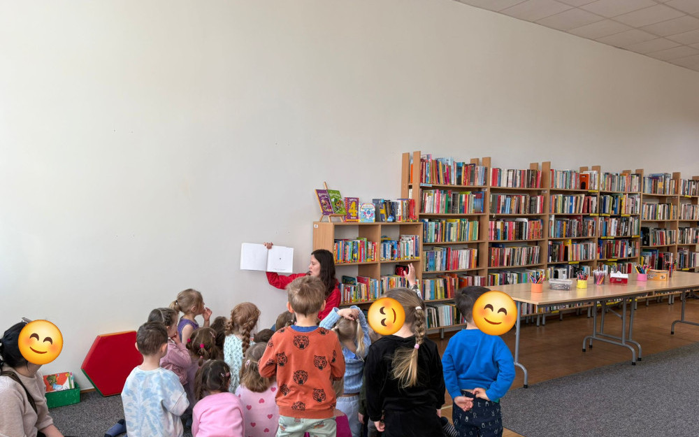 Bibliotekarka czyta książkę. dzieci siedzą na dywanie