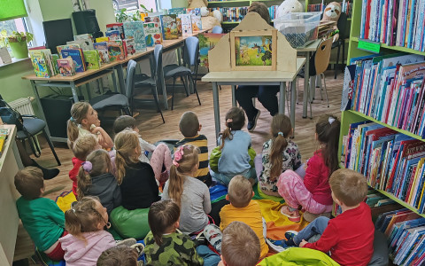 Pani Ania skryta za teatrzykiem kamisibai i zasłuchane dzieci.