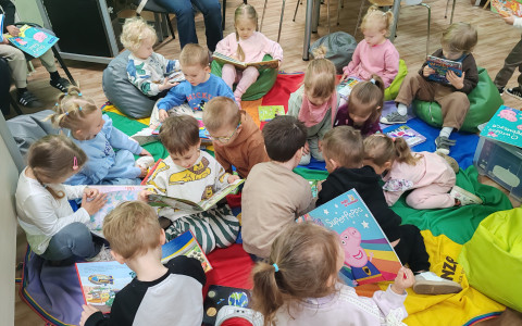 Dzieci z grupy „Kangurków” przeglądają biblioteczne książki