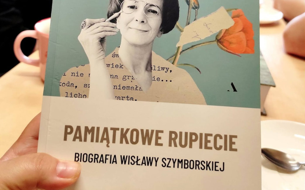 Okładka książki "Pamiątkowe rupiecie. Biografia Wisławy Szymborskiej", w tle uczestniczki DKK