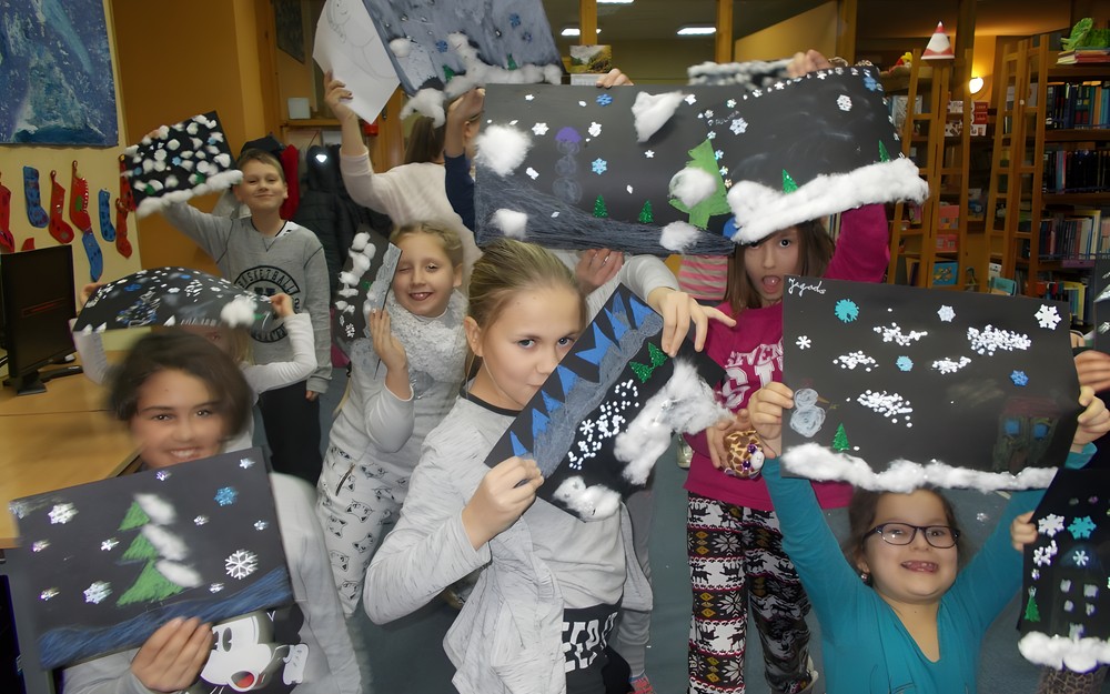 Grupowe zdjęcie uśmiechniętych dzieci z pracami