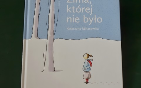 Okładka książki dla dzieci pod tytułem "Zima, której nie było", autorki Katarzyny Minasowicz.  Okładka jest biało-niebieska. Biały na dole i z tego koloru wyciągnięte są do góry dwa drzewa, jedno obok drugiego. Na niebieskim jest tytuł, imię i nazwisko.