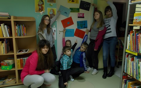 Uczestnicy ferii na tle drzwi z wizytówkami detektywów. Każdy tworzył własny rysunek z nazwą detektywa i charakterystycznym rysunkiem.