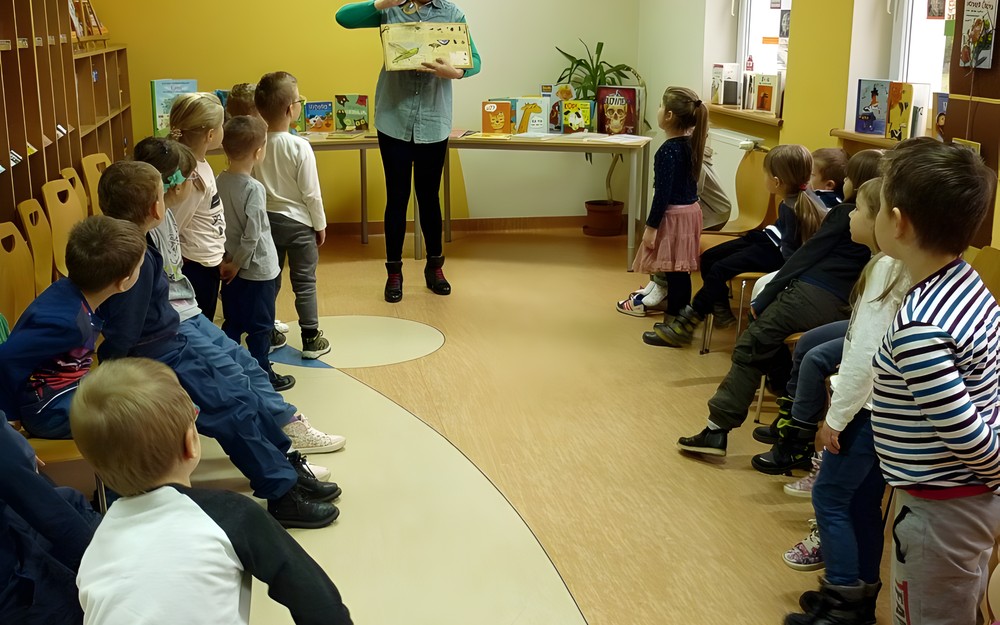 Dzieci z zaciekawieniem przyglądają się książce z lupą - OWADY